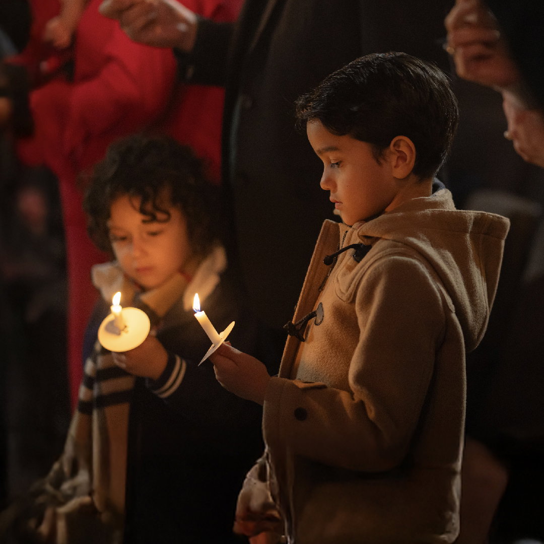 Niño y niña sosteniendo velas