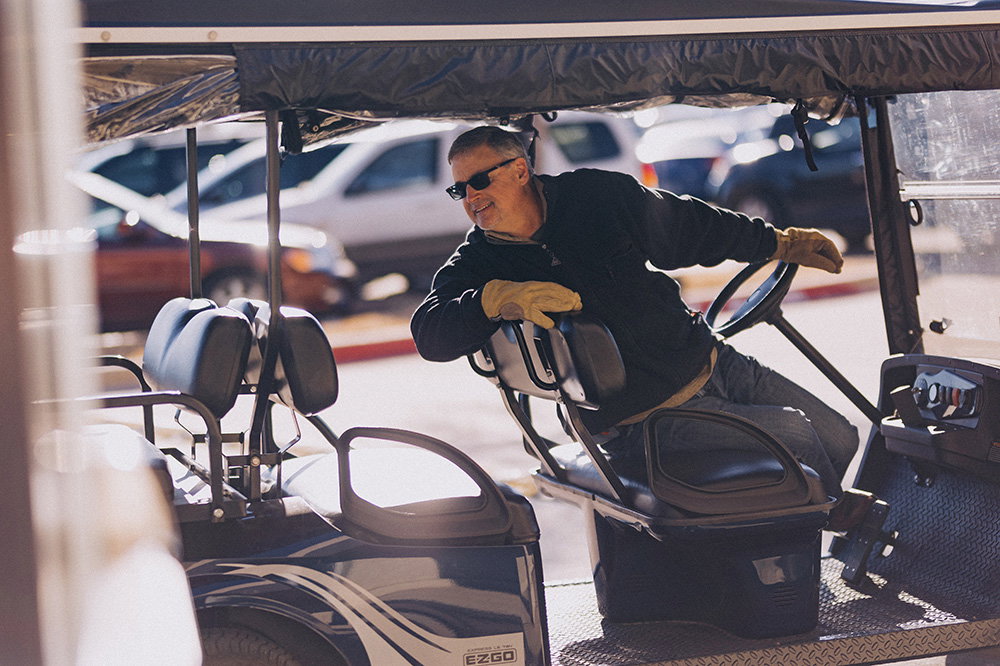 Hombre retrocediendo con un carrito de golf